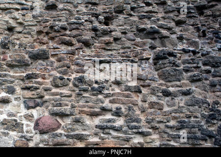 Mauerwerk Textur, Fragment der alten verfallenen Festung Wand aus Granit, Ziegel und Steine Stockfoto