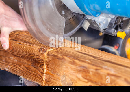 In der Nähe von einer Kreissäge schneidet ein Holz Stockfoto