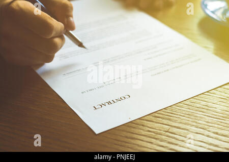 Vertragsdokument, zwei Männer melden Papier im Büro getönten verrauschtes Bild Stockfoto