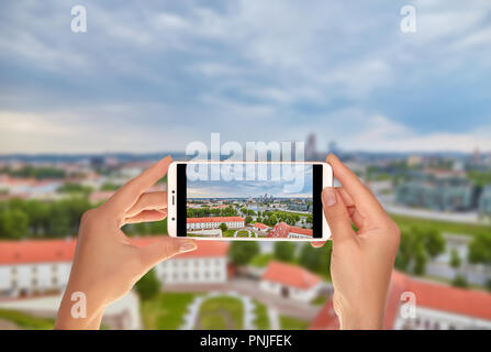 Ein Tourist ist ein Foto der Antenne Panoramablick auf die Hauptstadt von Litauen - Vilnius auf einem Mobiltelefon Stockfoto