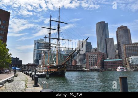 Ein Segelschiff im Hafen von Boston gegen die Skyline der Innenstadt von South Boston Seehafen, Boston, MA, USA Stockfoto