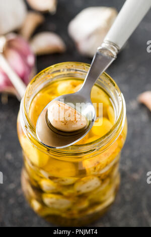 Marinierter Knoblauch. Eingelegten Knoblauch in jar auf alten Küchentisch. Stockfoto