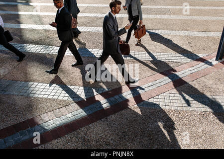 Geschäftsleute Pendeln zum Büro morgens Durchführung Büro Taschen und Mobiltelefone zu benutzen. Geschäftsleute in Eile, Büro zu Fuß auf Cit erreichen. Stockfoto