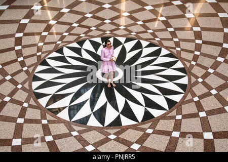 Dame in Rosa stehend auf dem Boden mosiac des Staates Illinois Gebäude Atrium, Downtown Chicago, IL. Stockfoto