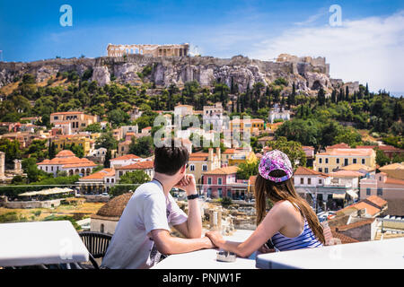 MONASTIRAKI, Athen, Griechenland, 11.JUNI 2016: Junges Paar an Caffe auf Monastiraki Platz und Blick auf die Akropolis am 11.Juni in Athen, Griechenland, 2016. Stockfoto