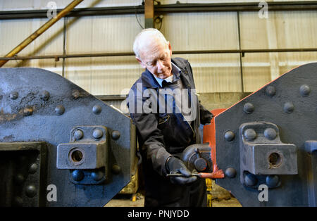 Freiwillige Malerei Abschnitt einer Dampflok im Workshop über die Brunnenkresse, Ropley Station, in der Nähe von Alton, Hampshire, UK. Stockfoto