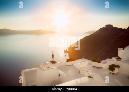 Mit Blick auf die Terrasse mit Tisch und Stühlen an der berühmten Sonnenuntergang auf Santorini, Griechenland, Stockfoto