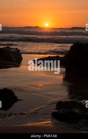 Sonnenuntergang über einem stürmischen Meer, von der Kapelle Porth Strand gesehen, Cornwall, UK. September. Stockfoto