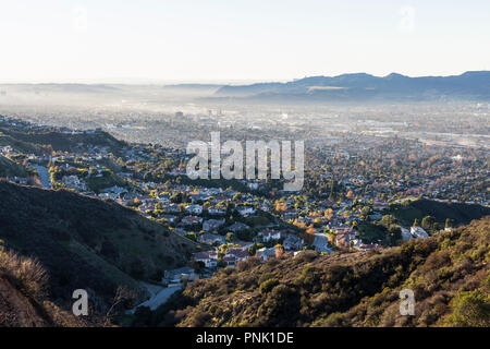 Smoggy Hügel Blick auf Canyon Wohnungen und Downtown Burbank mit dem San Fernando Valley, der Santa Monica Mountains und Los Angeles Kalifornien im Hinterg Stockfoto