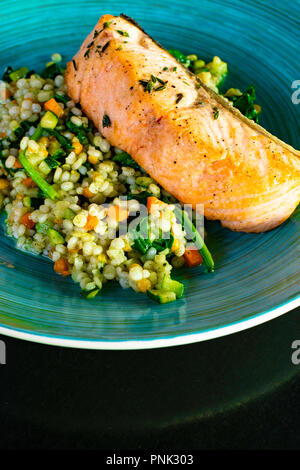 Gerste Salat und verschiedene Gemüse wie Mais, Karotten Kürbis Zwiebeln Gurken in der Platte und gebackenen Lachs mit Thymian Kraut Stockfoto