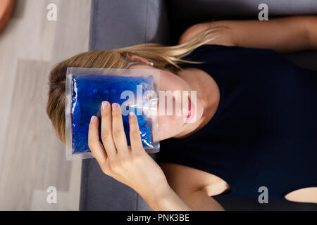 Ansicht von der Frau Hand Anwendung Ice Gel Pack auf der Stirn Stockfoto