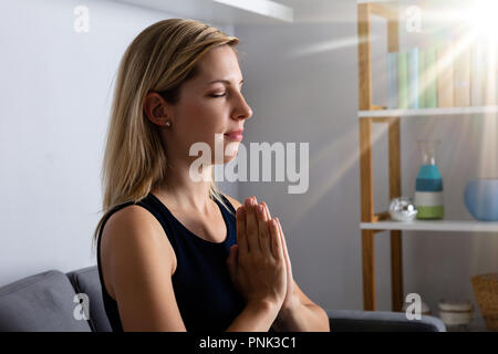 Licht fällt auf die junge Frau zu beten zu Gott Stockfoto