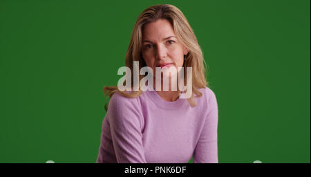 Blond kaukasische Frau tragen Pullover an der Kamera auf der Suche nach Green Screen Stockfoto
