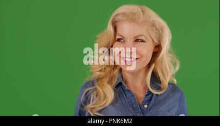 In der Nähe der attraktiven Blondine Frau suchen um Lächeln auf Green Screen Stockfoto