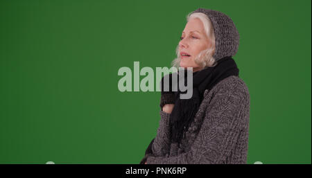 Reifen kaukasischen Frauen zittern bei kaltem Wetter auf der grünen Bildschirm Stockfoto