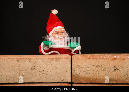 Santa Versuch, die Wand ein zuwanderungskonzept zu klettern Stockfoto