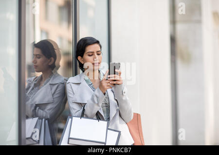 Arabische Frau mit einem Smartphone auf Shopping-Tour Stockfoto