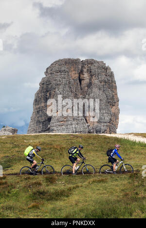 Cortina d'Ampezzo, Italien - 18 August, 2018: Drei Mountainbiker auf dem Berg Trail, an einem bewölkten Sommertag. Im Hintergrund ist der Hauptturm des Stockfoto
