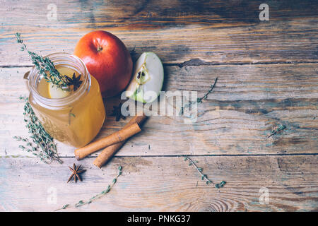 Apple Cider (Apfelwein) oder Glühwein Chai mit Zimtstangen und frische Äpfel auf Holz- Hintergrund. Herbst Getränke. Winter Stimmung. Kopieren Sie Platz. Stockfoto