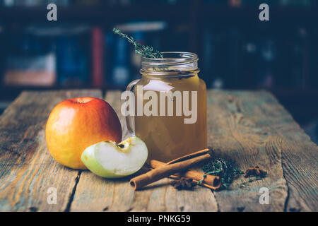 Apple Cider (Apfelwein) oder Glühwein Chai mit Zimtstangen und frische Äpfel auf Holz- Hintergrund. Herbst Getränke. Winter Stimmung. Kopieren Sie Platz. Stockfoto