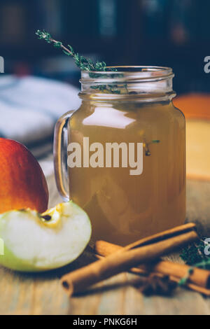 Apple Cider (Apfelwein) oder Glühwein Chai mit Zimtstangen und frische Äpfel auf Holz- Hintergrund. Herbst Getränke. Winter Stimmung. Stockfoto