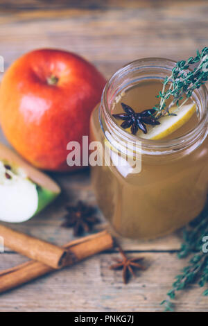 Apple Cider (Apfelwein) oder Glühwein Chai mit Zimtstangen und frische Äpfel auf Holz- Hintergrund. Herbst Getränke. Winter Stimmung. Stockfoto