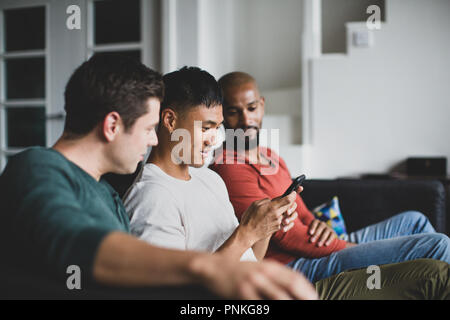Männliche Freunde auf Smartphone zusammen Stockfoto
