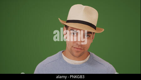Stattliche tausendjährigen Latino Mann mit Fedora auf Green Screen Stockfoto