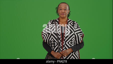 Portrait von stilvollen alten schwarzen Frau mit festlichen Schal auf Green Screen Stockfoto