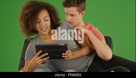 In der Nähe des Tausendjährigen mit Tablet online auf Green Screen zu durchsuchen Paar Stockfoto