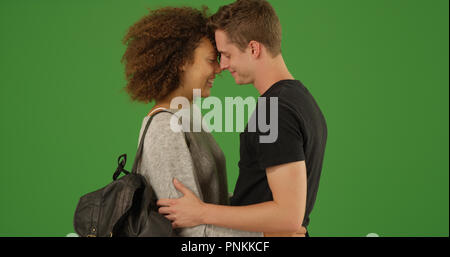 Romantische tausendjährigen interracial Paare über Green Screen zu küssen. Stockfoto