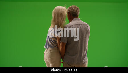 Ansicht der Rückseite des romantischen, alten Paar teilen intimen Moment auf Green Screen Stockfoto