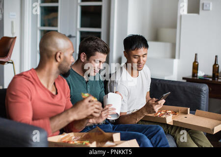 Männliche Freunde Essen verschiedene takeout Mahlzeiten zusammen Stockfoto
