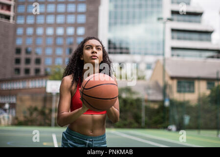 Junge Erwachsene weiblichen Basketball Player über ein Hoop schießen Stockfoto