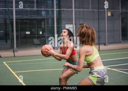 Junge Erwachsene weiblichen Basketball Player über ein Hoop schießen Stockfoto