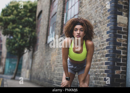 Junge erwachsene Frau eine Pause auf einen Lauf in der Stadt Stockfoto