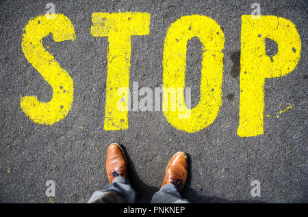 Stop-Schild auf dem Boden vor FEETS Stockfoto