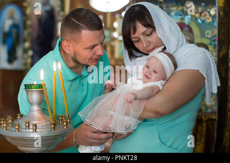 Belarus, Gomel, am 14. Juli 2018. Die Kirche ist Zyabrsky. Die Eltern werden durch ein Kind getauft. Patinnen. Mama und Papa halten Sie das Baby in den Armen in der Stockfoto