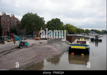 Arbeiten an der Themse Tideway Tunnel bei Putney Damm Vorland Website, gesehen von Putney Bridge mit Arbeiter, zwei Kräne und ein Lastkahn. Stockfoto