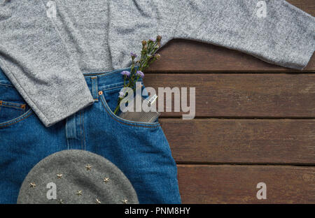 Modische Kleidung und Accessoires für Herbst auf Holz- Hintergrund. Fashion Concept Stockfoto