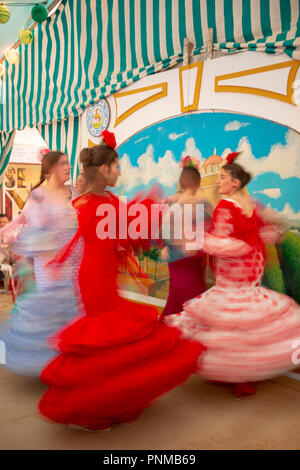Tanzen junge spanische Frauen, Frauen mit Flamenco Kleider in bunten Festzelt, Portonovo, Feria de Abril, Sevilla Stockfoto