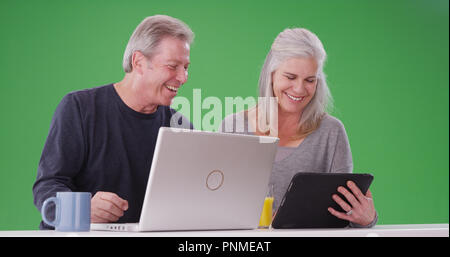 Porträt eines charmanten alten weißen Paar über drahtlose Geräte auf Greenscreen Stockfoto