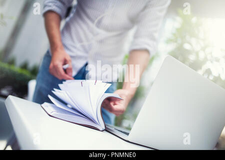 Porträt junger hübscher Kerl mit Kopfhörern und Gläser in der modernen Stadt. Junge Unternehmer Vorbereitung in Stadt caffe zu arbeiten. Stockfoto