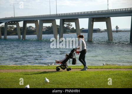 Dame schieben Kinderwagen, dem San Remo Brücke, San Remo, Phillip Island, Victoria. Stockfoto