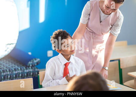 Lehrer Kind Hilfe bei den Hausaufgaben im Unterricht in der Schule Stockfoto