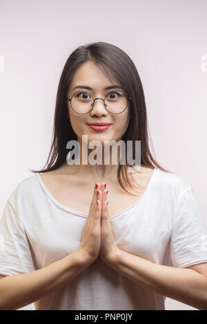 Asiatische Frau Gruß, die Handflächen zusammen, willkommen Ausdruck. Stockfoto