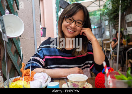 Junge Frau fröhlich trinken Kaffee im Freien Stockfoto
