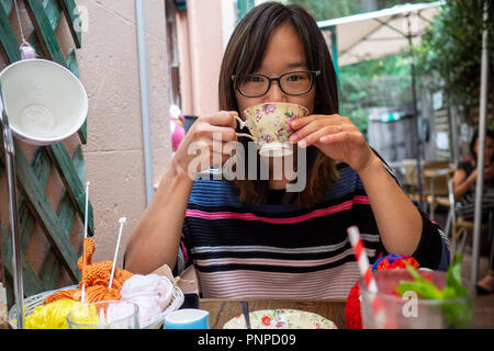 Junge Frau fröhlich trinken Kaffee im Freien Stockfoto