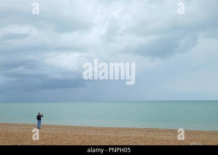 Hastings, East Sussex, UK. 22 Sep, 2018. UK Wetter: Herbstliches Wetter mit nur einer leichten Brise in der Luft und ruhige See, eine willkommene Rückkehr aus den vergangenen Tagen. Ein Mann nimmt ein Bild von den schönen Farben draußen auf dem Meer. © Paul Lawrenson 2018, Foto: Paul Lawrenson/Alamy leben Nachrichten Stockfoto