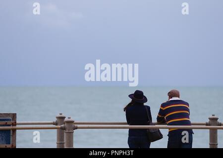 Hastings, East Sussex, UK. 22 Sep, 2018. UK Wetter: Herbstliches Wetter mit nur einer leichten Brise in der Luft und ruhige See, eine willkommene Rückkehr aus den vergangenen Tagen. Dieses Paar, eine Frau mit einem schwarzen Hut und Mann mit einem gestreiften Pullover Meerblick. © Paul Lawrenson 2018, Foto: Paul Lawrenson/Alamy leben Nachrichten Stockfoto